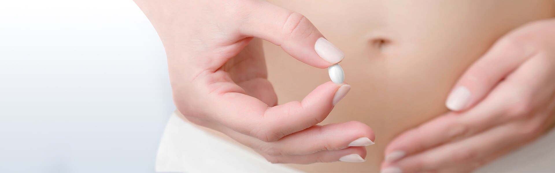 Mâna unei tinere ținând o pilulă